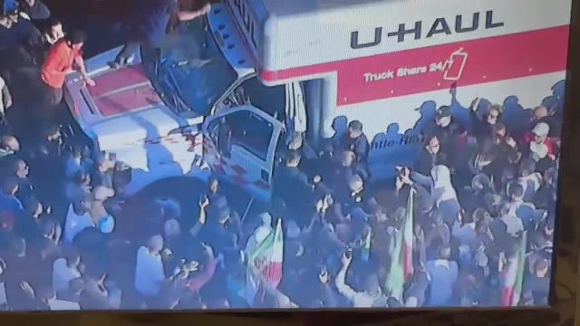 Aerial video from ABC7 shows police detaining the driver of a U-Haul Truck that drove through an Iranian pro-monarchist, anti-regime march today in Los Angeles, as crowds of protesters attempt to attack the truck and driver